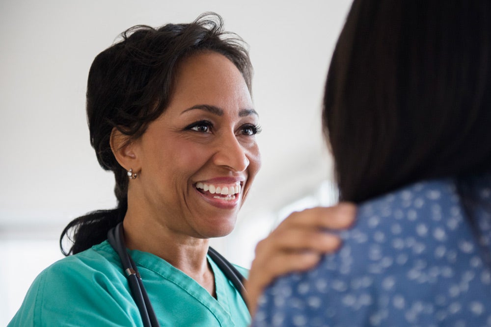 Doctor comforting patient and smiling
